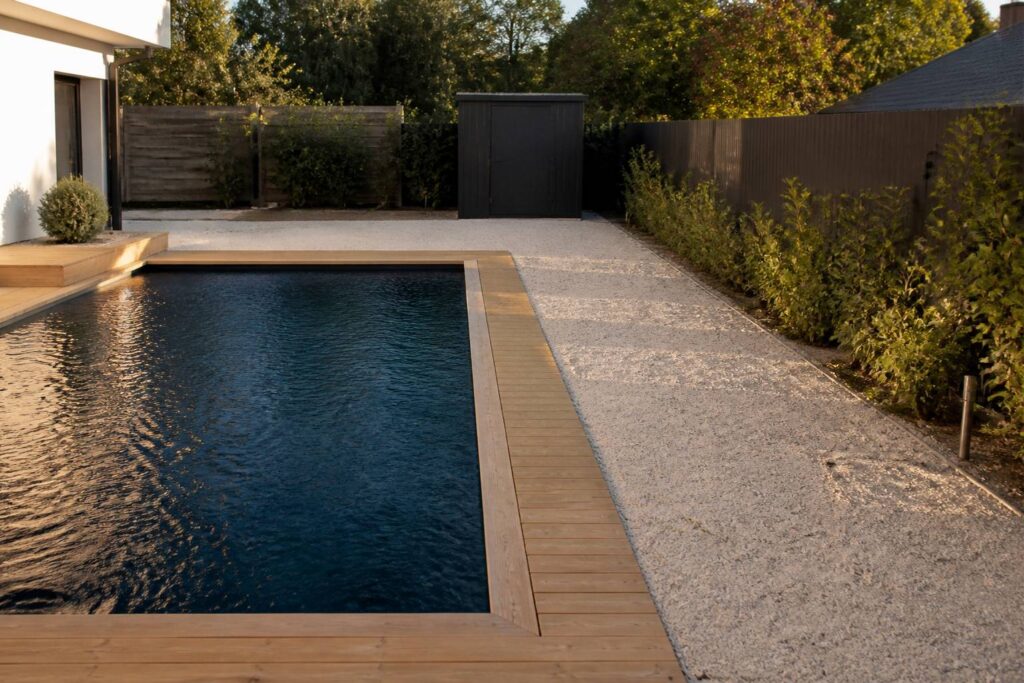 Piscine privée dans un jardin avec la clôture du voisin